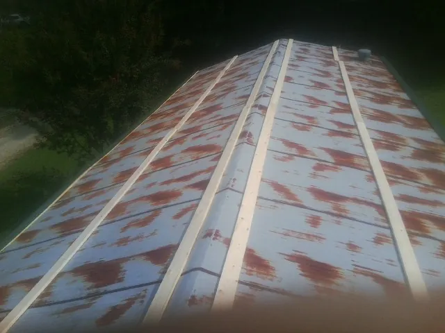 Rusted metal roof panels with new wood purlins before replacement — Storm Damage Roof Repair in Ellerbe by Roofing Brothers