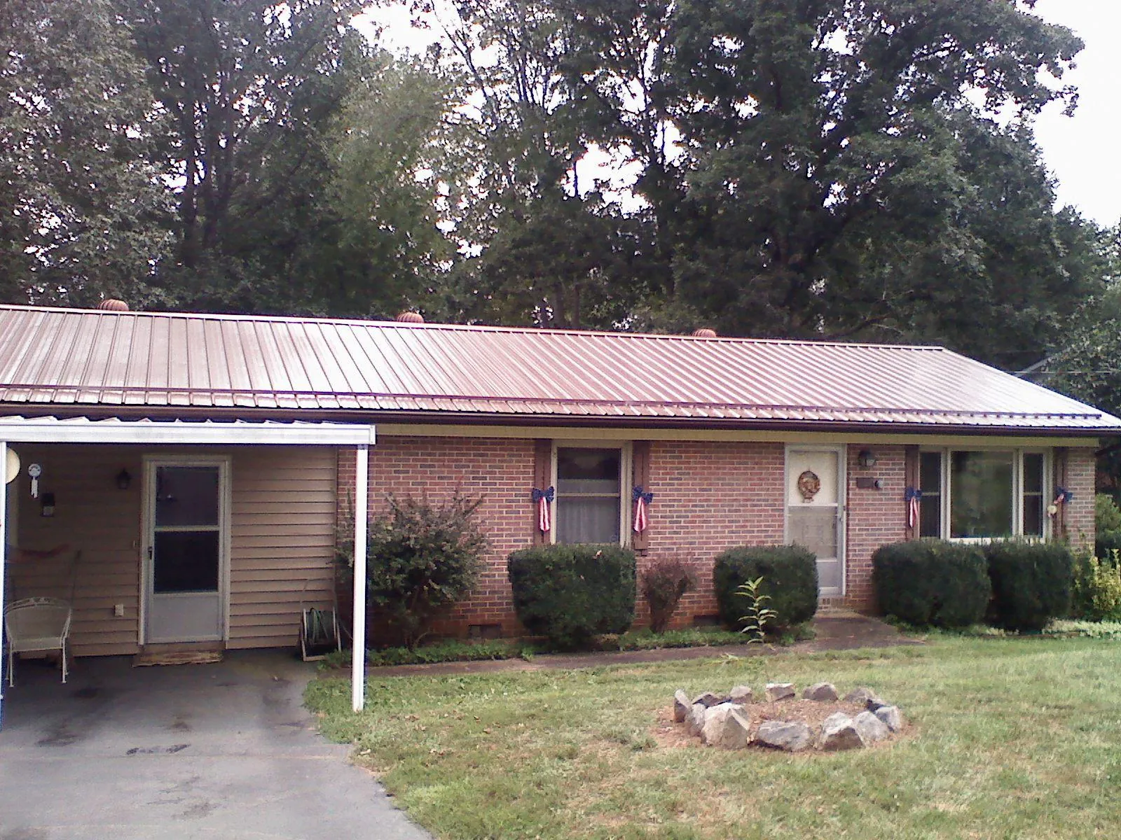 Bronze metal roof and carport on a brick ranch home — Roof Repair work by our crew in Ellerbe