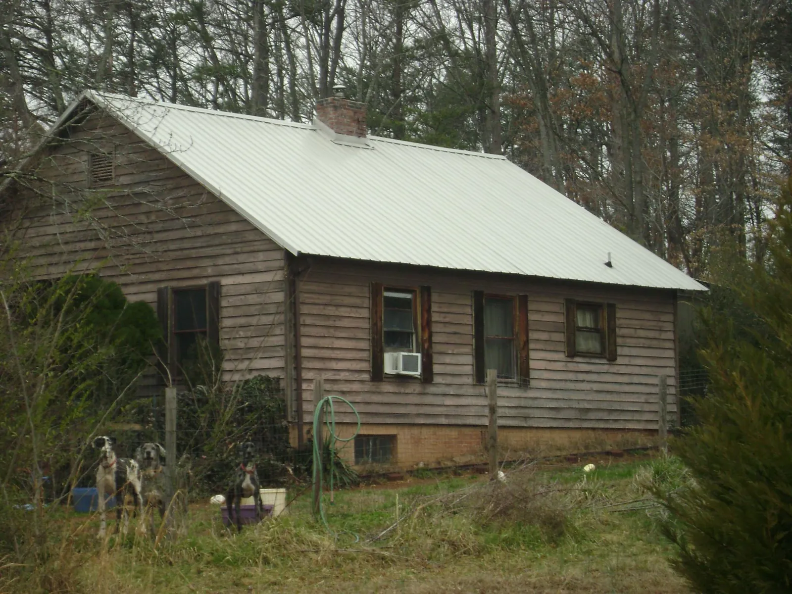 White metal roof on an old wood sided farmhouse, from a Metal Roof Installation job in Ellerbe